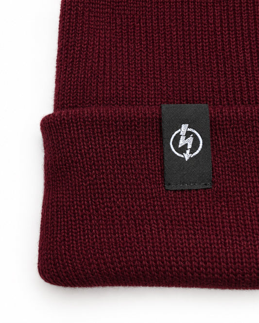 Bio Baumwolle Beanie Burgundy – Detailfoto des gewebten Useless-Labels