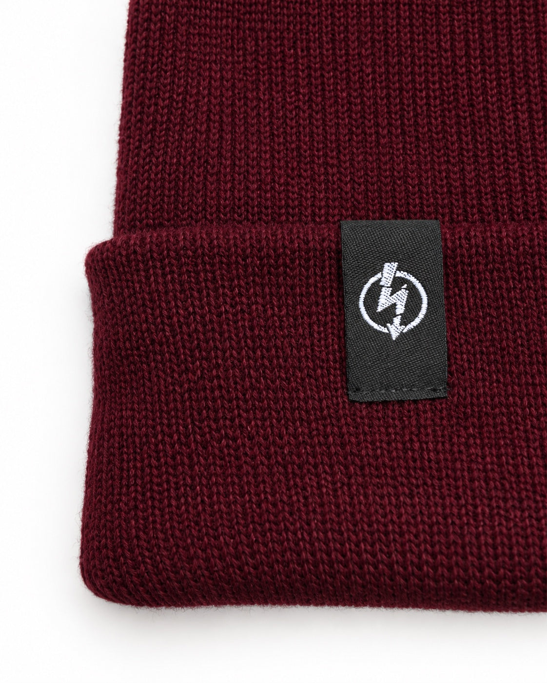 Bio Baumwolle Beanie Burgundy – Detailfoto des gewebten Useless-Labels