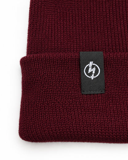 Bio Baumwolle Beanie Burgundy – Detailfoto des gewebten Useless-Labels
