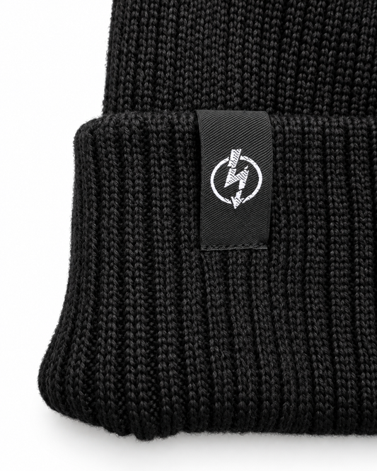 Useless Bio Baumwolle Beanie Schwarz – Detailansicht des angenähten gewebten Logo-Labels